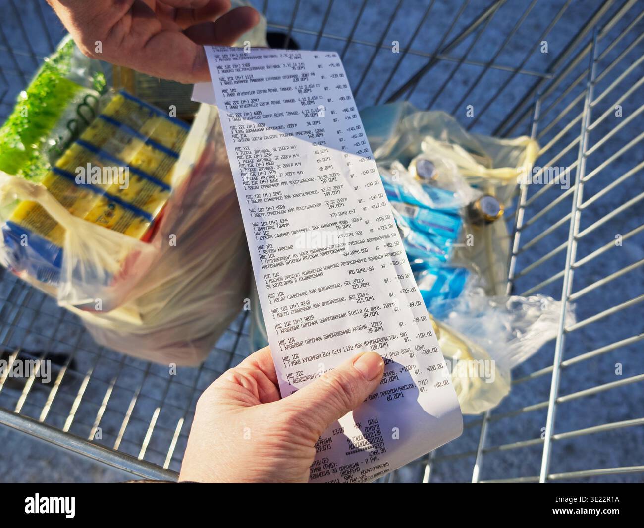 Kirov, Russia - 8 febbraio 2026: Il cliente è in possesso di una ricevuta che elenca i prodotti alimentari acquistati durante un viaggio di shopping. La ricevuta mostra il conf. Pagamento Foto Stock