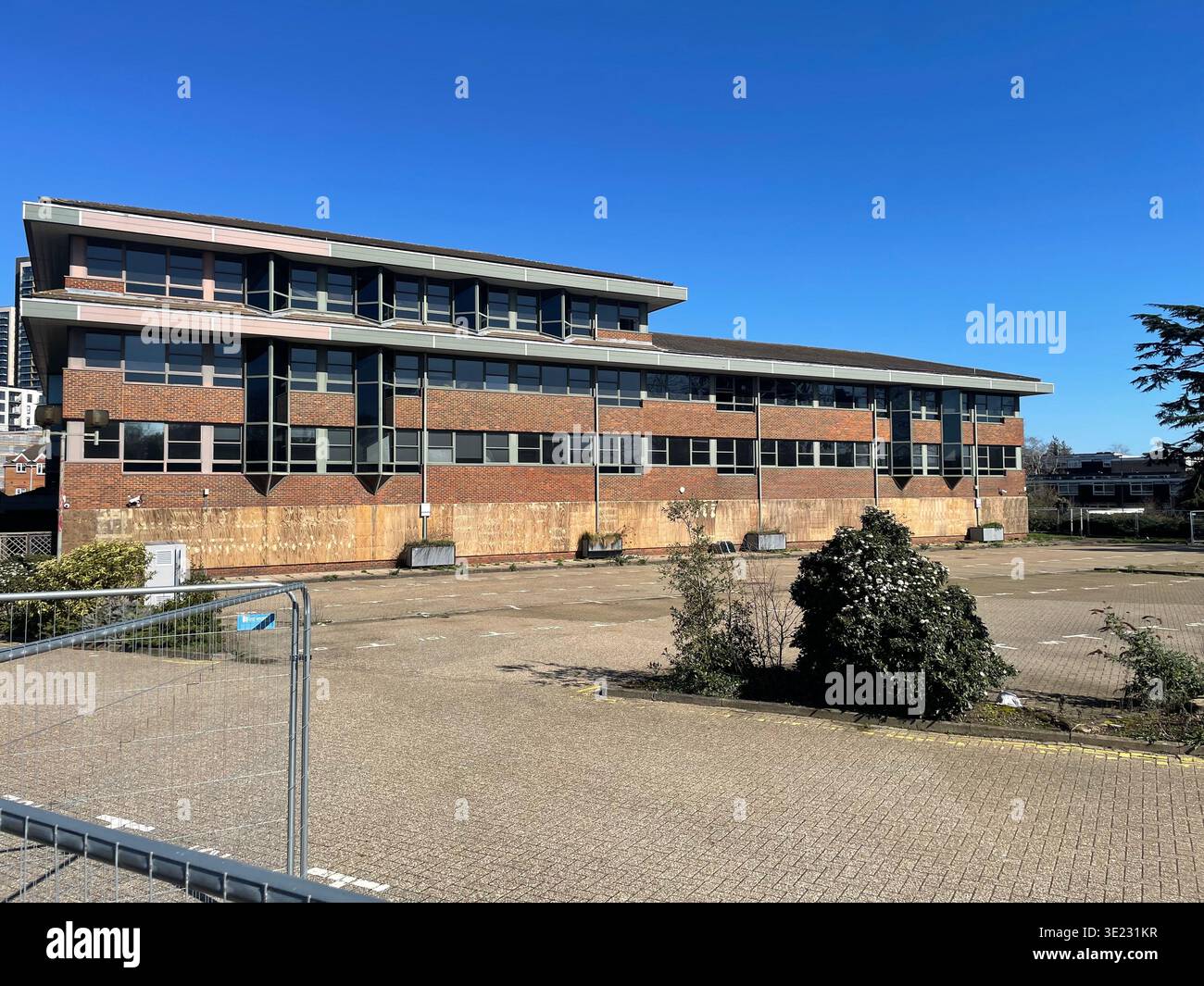 Quadrant Court Woking, edificio per uffici vuoto con piazzale vuoto e recinzione, ex sede del Consiglio della contea di Surrey, Woking, Surrey, Inghilterra Foto Stock