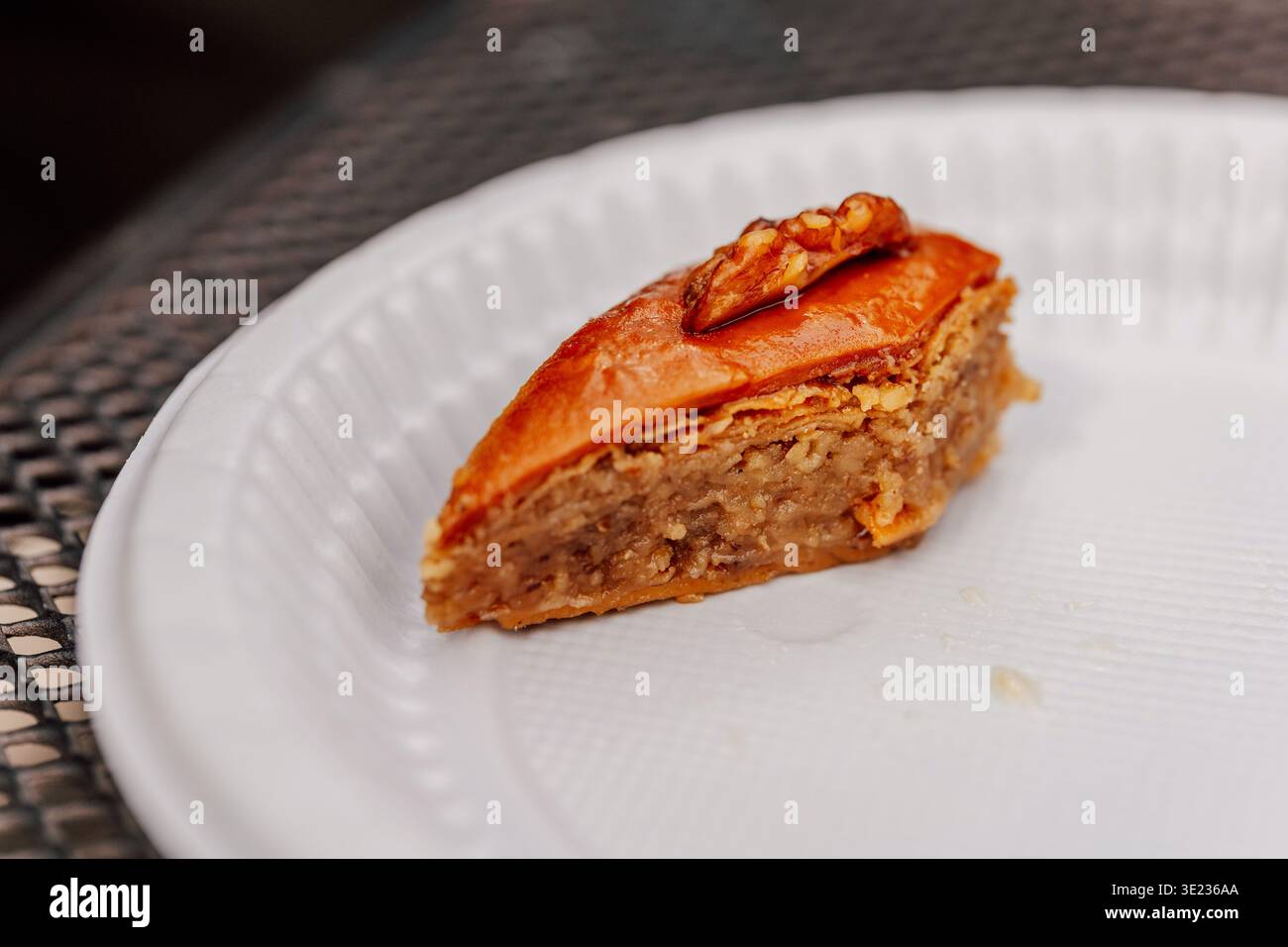 Vivace scena di pasta fillo glassata al miele con noci in mostra su Street Food Ceramic Dish Foto Stock
