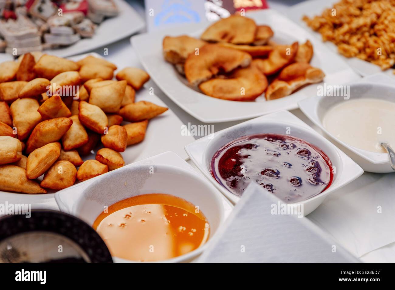 Farina uzbeka con marmellata. Baursak fritti durante la festa uzbeka di Nauryz Foto Stock