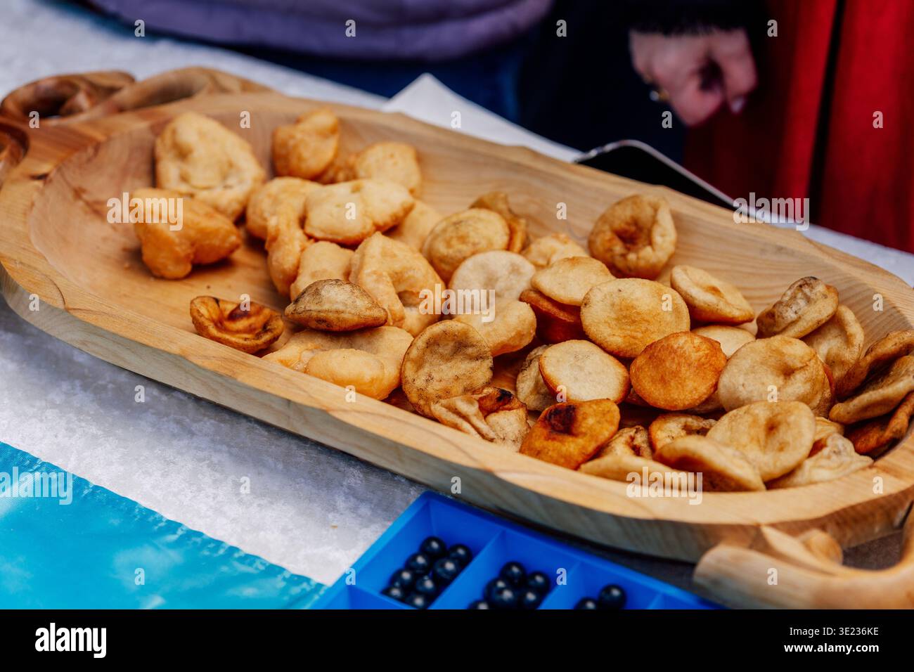 Baursak kazaki in piatti nazionali in legno. Impasto fritto per le vacanze a Nauryz Foto Stock