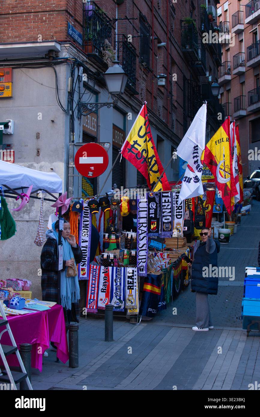 Venditori ambulanti e bancarelle del mercato lungo la Ribera de Curtidores nell'iconico Rastro di Madrid, che mostra il commercio locale e la vibrante attività mattutina Foto Stock