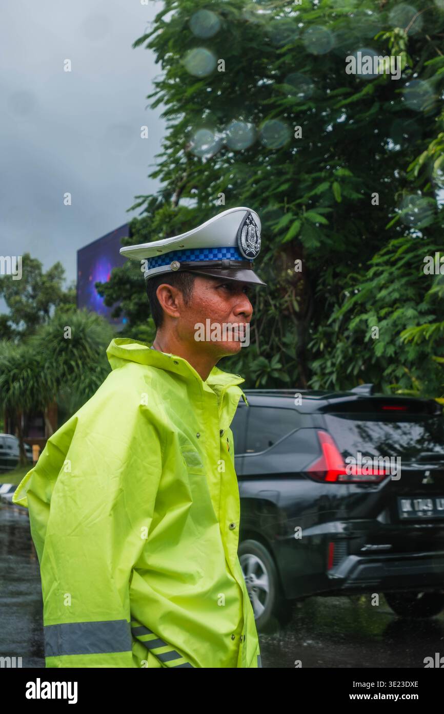 Agente indonesiano della polizia stradale a Raincoat a Bali Foto Stock