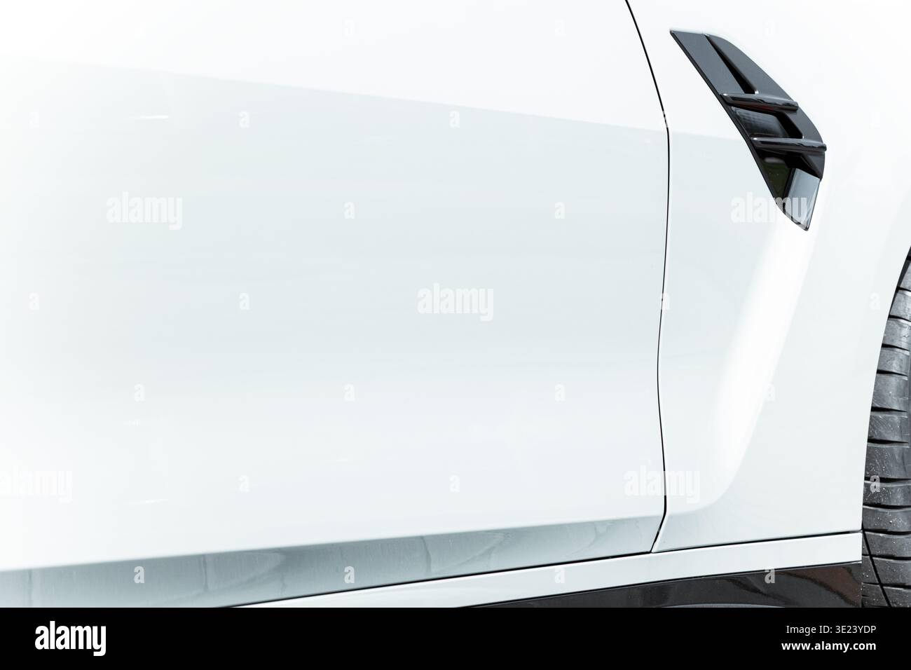Una vista dettagliata dell'esterno bianco lucido e liscio di un'automobile moderna, evidenziandone gli elementi aerodinamici e le linee nitide Foto Stock