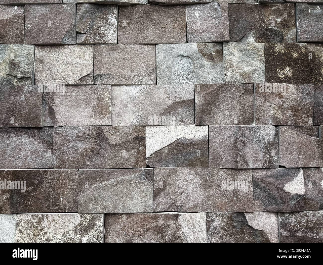 Struttura di fondo di un muro di pietra ruvida costruito con blocchi rettangolari irregolari di ardesia grigia Foto Stock
