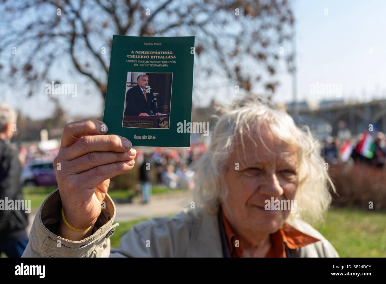 Il partecipante tiene un opuscolo intitolato “Active Creed of National partisanship” su Viktor Orbán alla marcia della Pace del 15 marzo 2026 a Budapest. Foto Stock