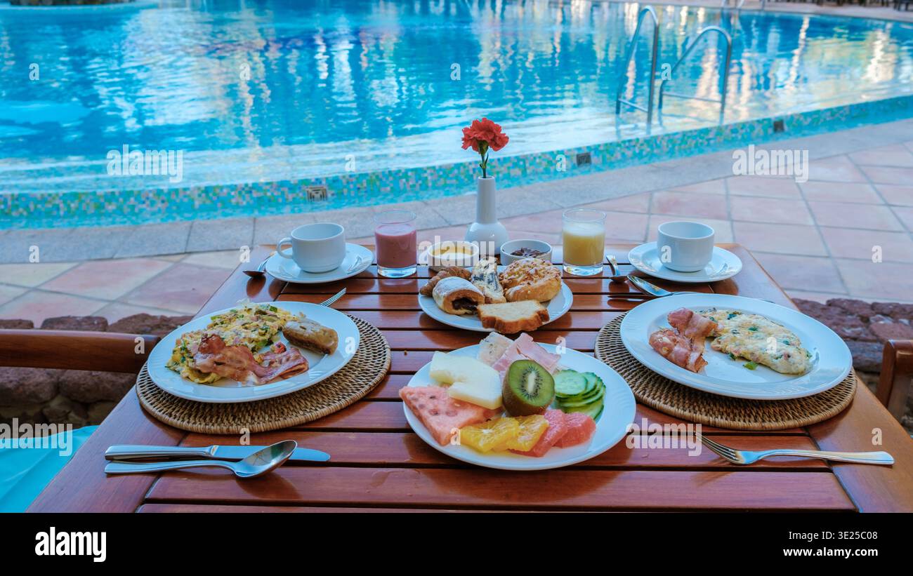 Rilassante mattinata a bordo piscina a Gran Canaria con una ricca colazione a base di frutta fresca, pasticcini e piatti salati. Un inizio perfetto per una vacanza di lusso nella soleggiata Spagna. Foto Stock