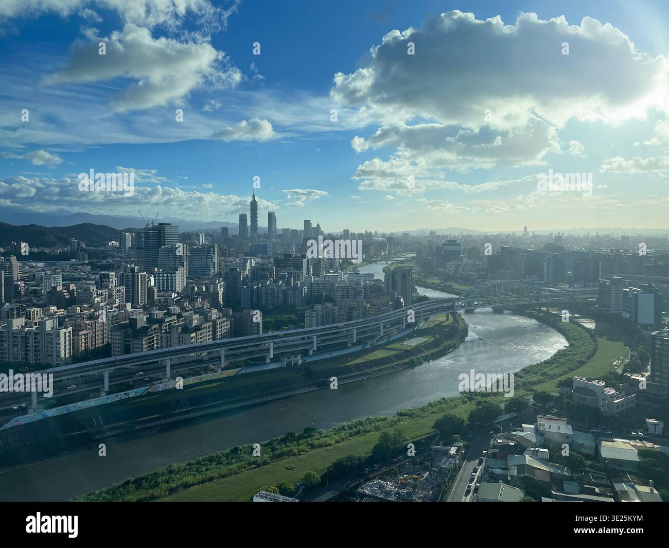 Skyline moderno della città con fiume e ponte sotto il suggestivo cielo blu - Immagine stock catturata con smartphone