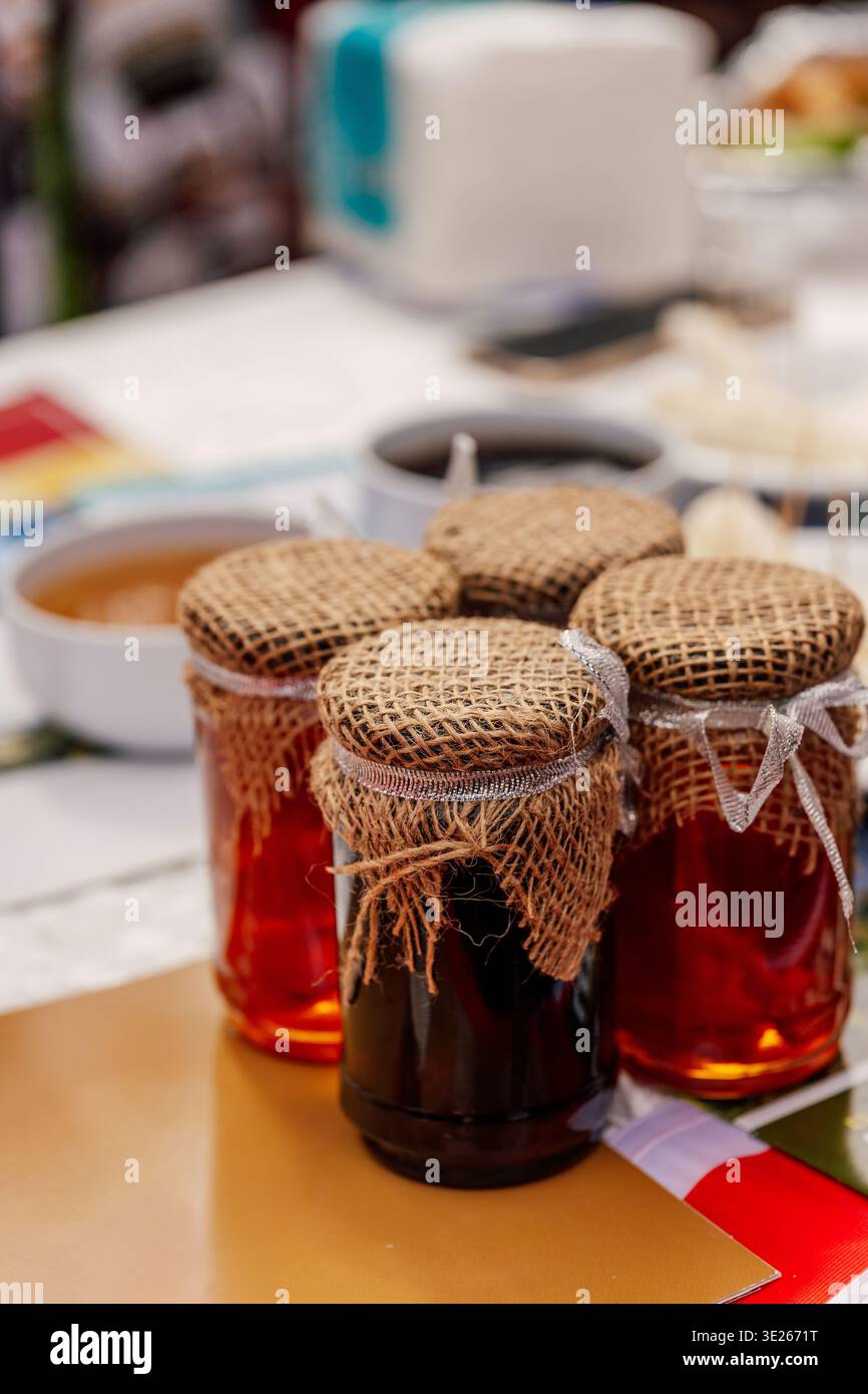 Immagini vivide di conserve fatte in casa esposte sul Country Style Marketplace Table con un'atmosfera calda Foto Stock