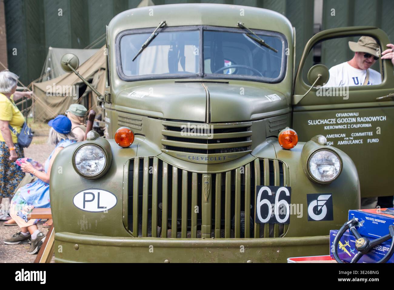 IWM Duxford Summer Airshow - camion militare Chevrolet d'epoca verde oliva esposto ad un evento di rievocazione polacca con visitatori, tende in tela e hist Foto Stock