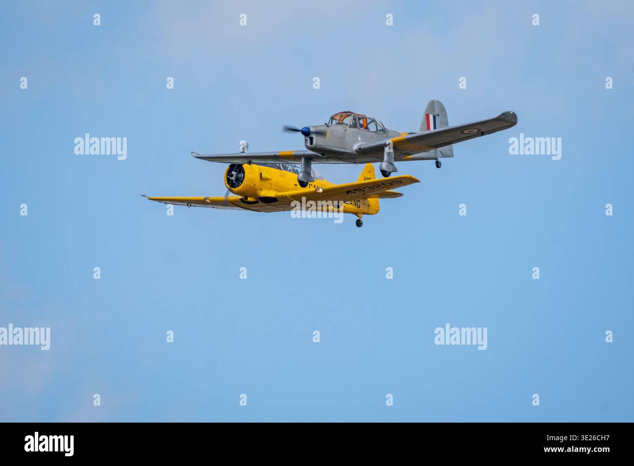 Headcorn Battle of Britain Airshow - due aerei da addestramento d'epoca, un addestratore monomotore giallo brillante e un aereo biposto argento, volano in forma stretta Foto Stock