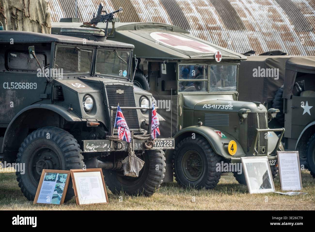 Headcorn Battle of Britain Airshow - fila di camion militari d'epoca restaurati e un'ambulanza della seconda guerra mondiale esposta con bandiere dell'Unione in un giardino all'aperto Foto Stock
