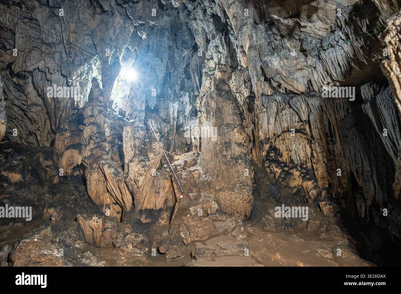 Grutas Lanquín Guatemala - i pozzi di luce del sole perforano l'interno di una grotta calcarea umida che rivela stalattiti e stalagmiti drammatiche, formazioni rocciose ruvide a. Foto Stock