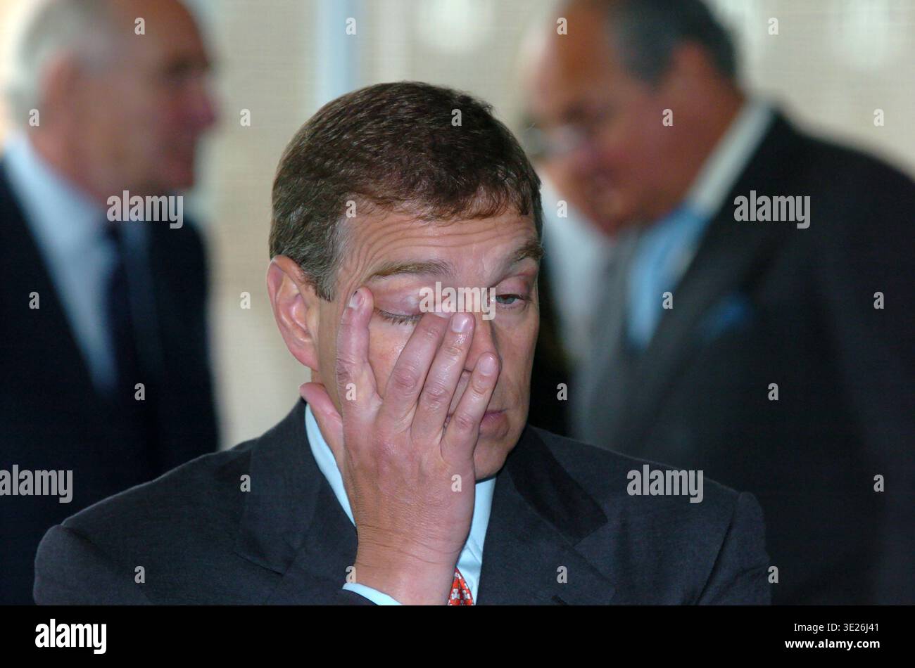 Il principe Andrew, un occhio chiuso, durante una visita a Kingston Communications (ora KCOM), Hull, Regno Unito, il 6 luglio 2004. È raffigurato sfregare Foto Stock