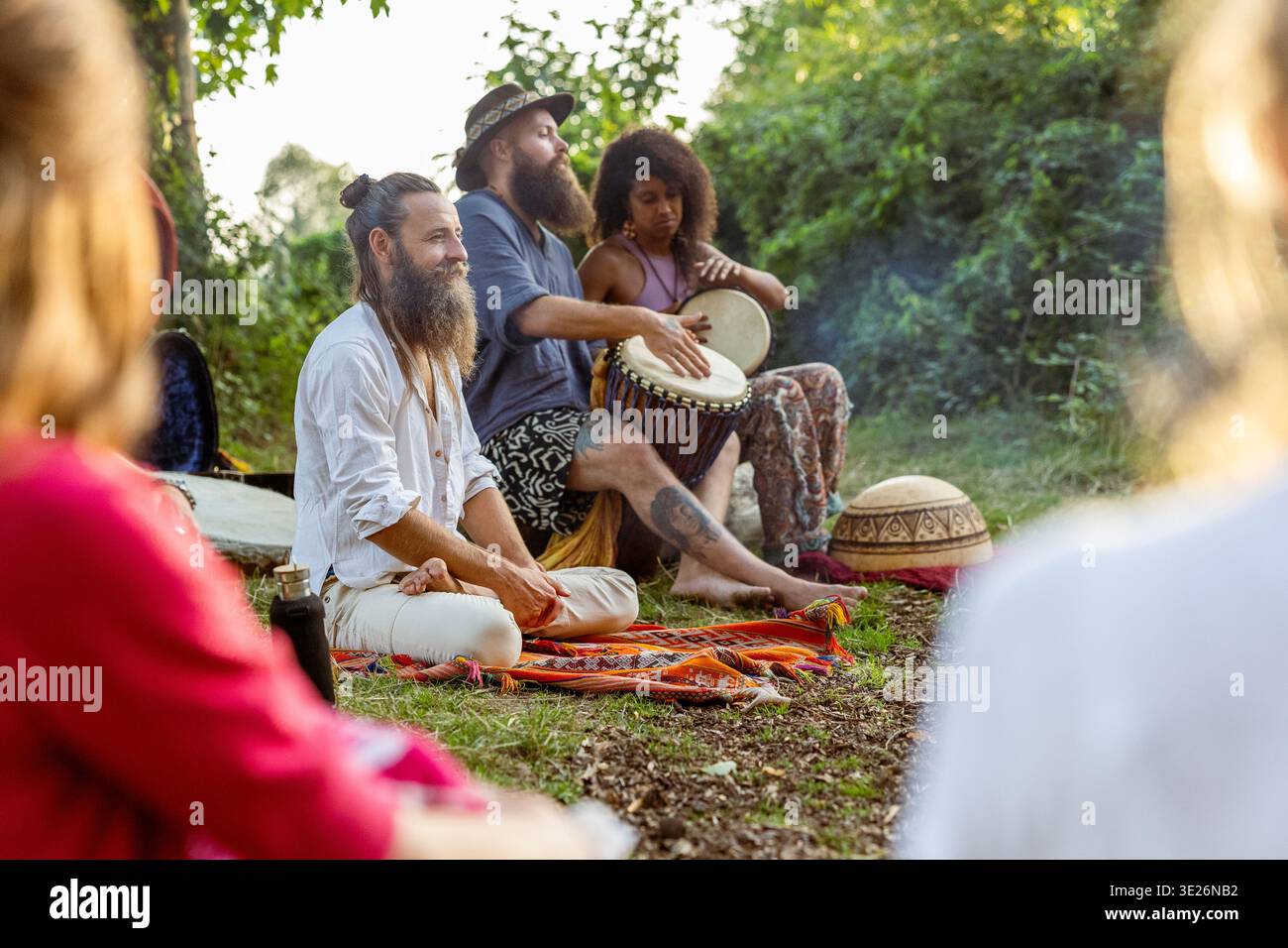 Gruppo di persone che si godono una sessione di percussioni all'aperto, promuovendo la connessione e la spiritualità Foto Stock