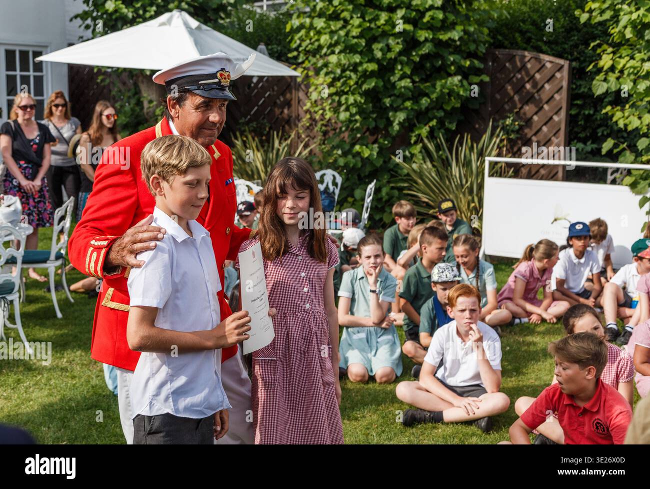 Il Royal Swan Marker David Barber presenta il certificato di premiazione ai bambini delle scuole durante la cerimonia all'aperto Foto Stock