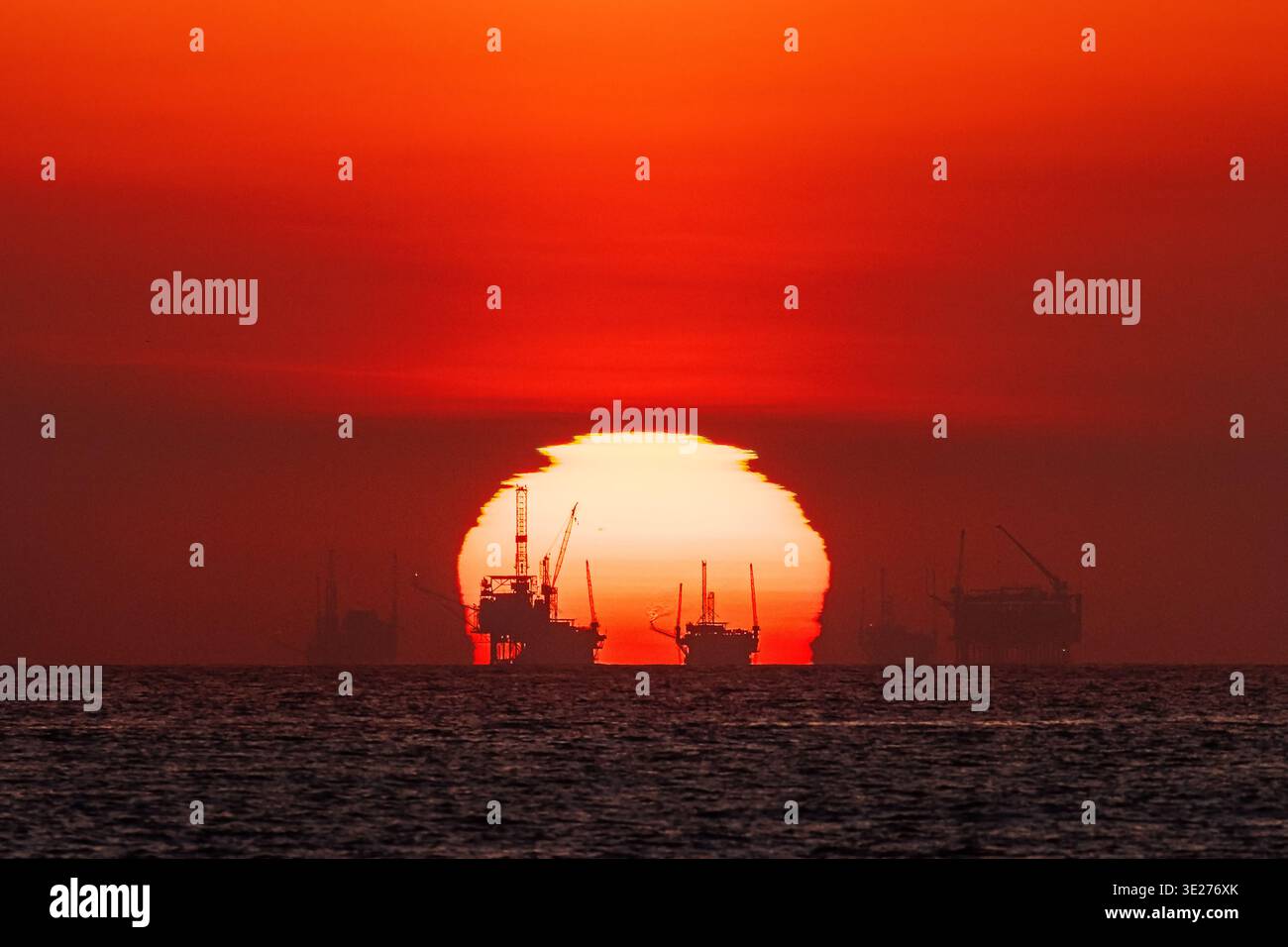 Tramonto dietro le piattaforme petrolifere offshore sulla costa di Santa Barbara, California Foto Stock