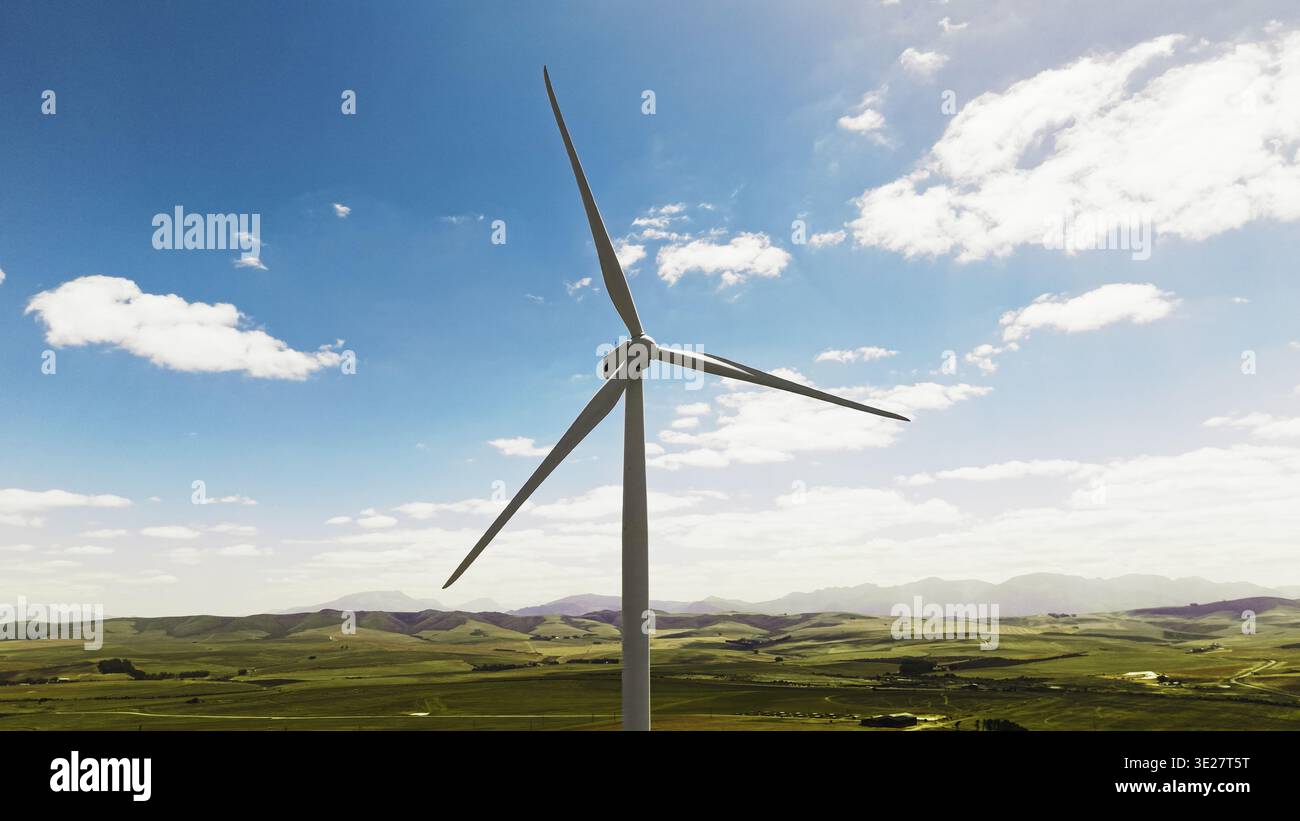 Cielo blu, natura e turbina eolica in erba per energie rinnovabili, sostenibili o ecocompatibili. Campo, nuvole e mulino a vento per le risorse naturali Foto Stock