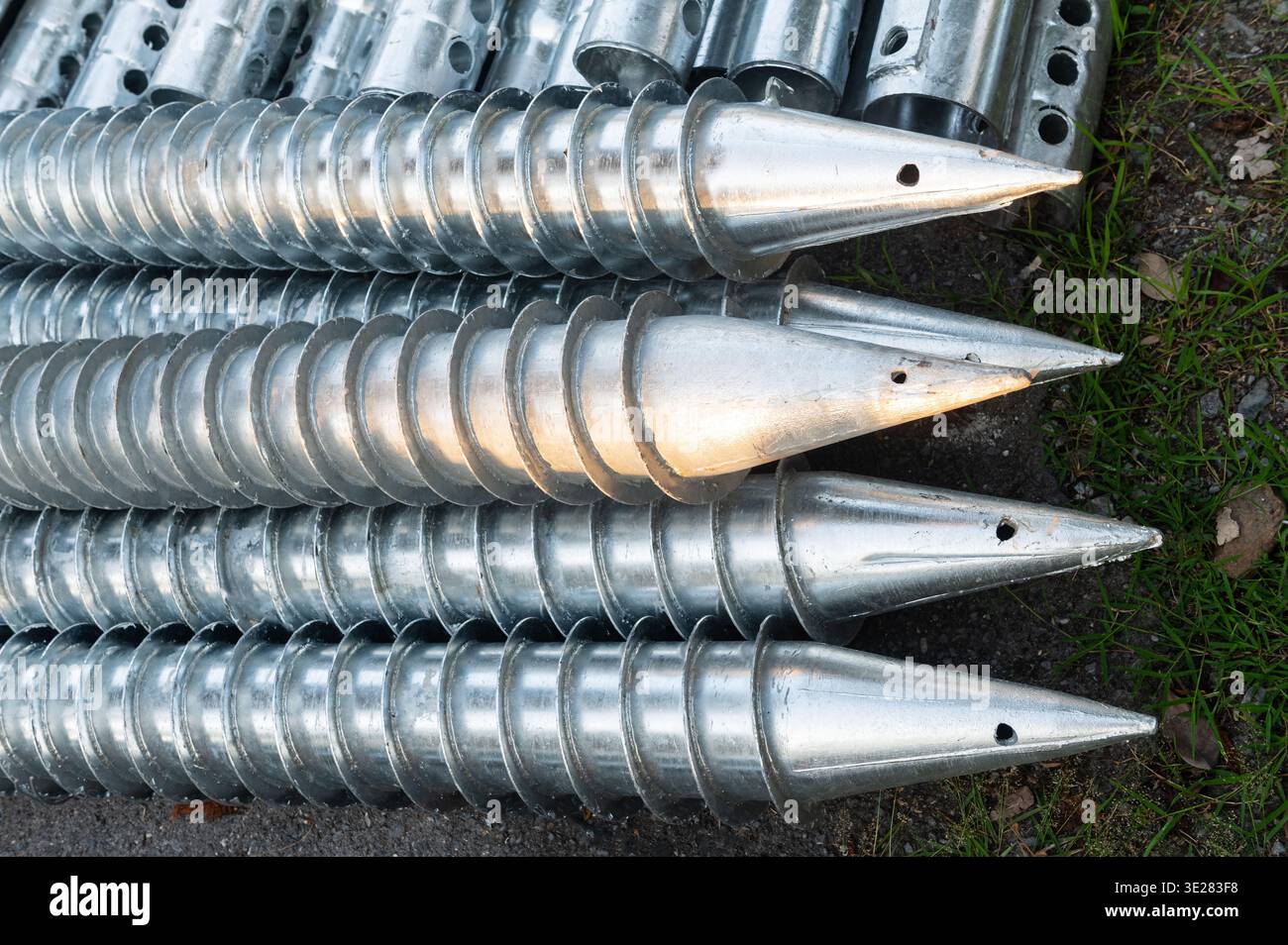 Pali di vite di messa a terra in acciaio zincato per la costruzione di fondazioni su superfici in calcestruzzo Foto Stock