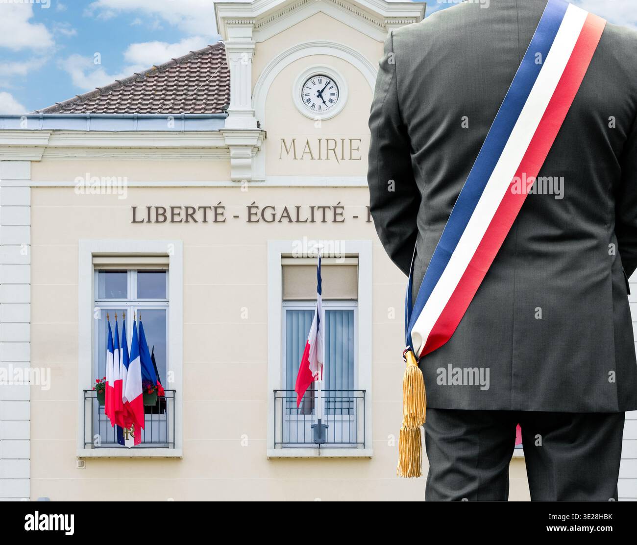 Vista posteriore del sindaco francese con fascia tricolore davanti al municipio con iscrizione Liberty Equality Fraternity Foto Stock