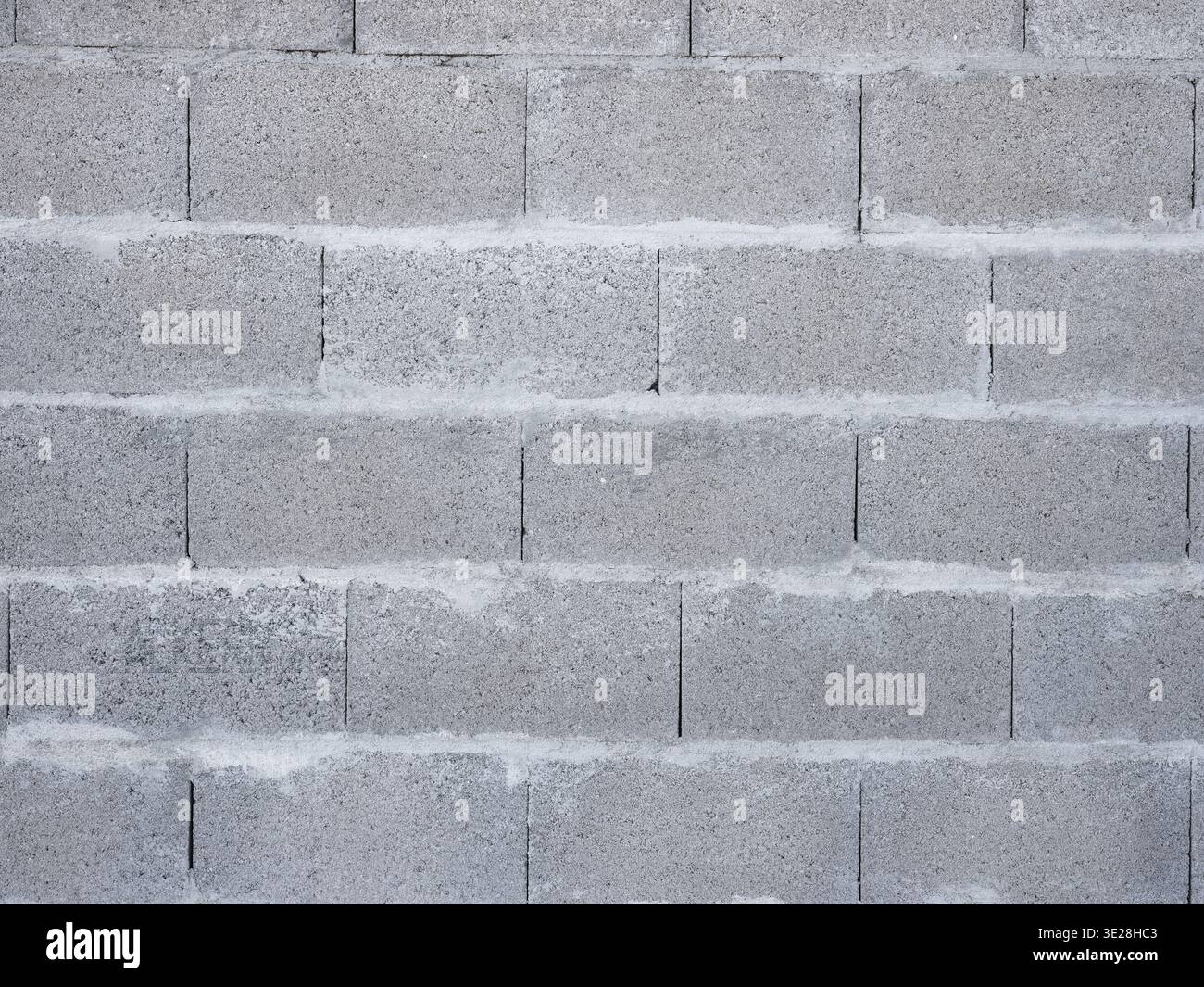 Primo piano di una parete grigia in cemento con blocchi di cemento con giunti a Malta visibili Foto Stock