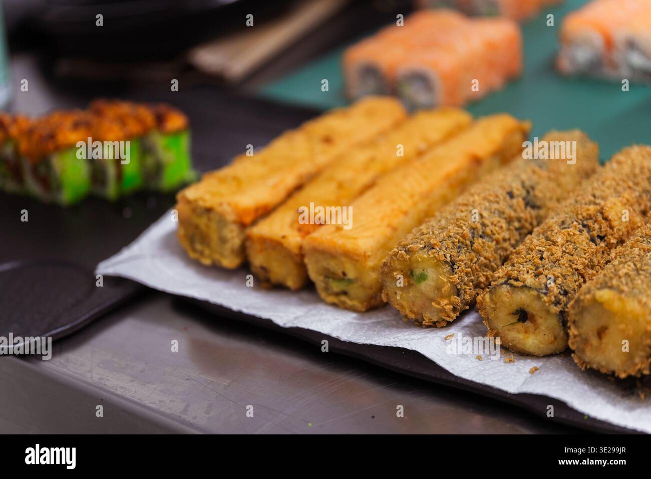 Dita di sushi fritte croccanti su vassoio di carta con rivestimento Golden Crumb, raffreddamento a lotti successivo a fresco Foto Stock