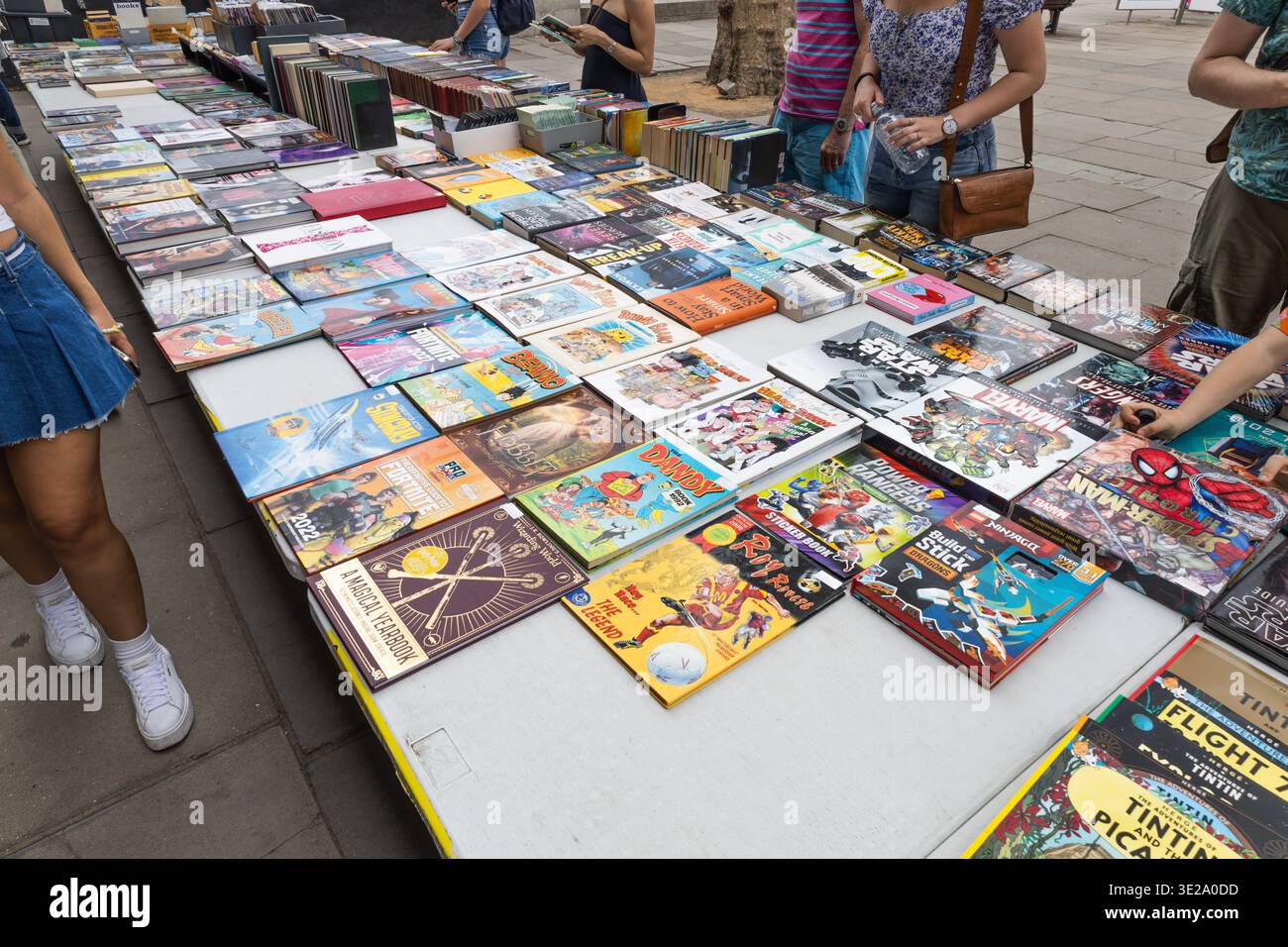 Persone che sfogliano libri colorati in un mercato all'aperto. Londra, Regno Unito, 24 giugno 2023 Foto Stock