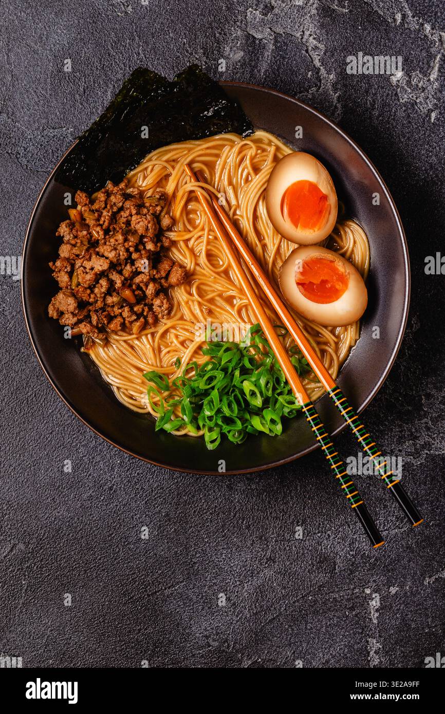 Una ciotola di ramen con spaghetti, carne e cipolle verdi, vista dall'alto. Foto Stock