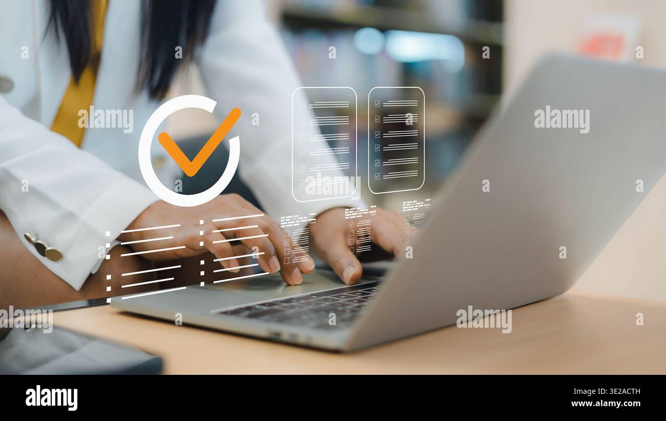 Donna d'affari che lavora su un notebook con una lista di controllo virtuale e un'icona con il segno di spunta arancione. Concetto di garanzia di qualità, conformità agli standard, documenti certificati Foto Stock