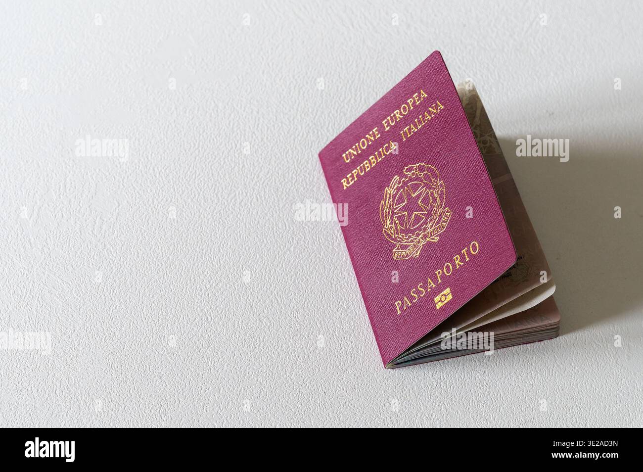 Passaporto italiano su sfondo testurizzato, che rappresenta identità, viaggi e relazioni internazionali Foto Stock