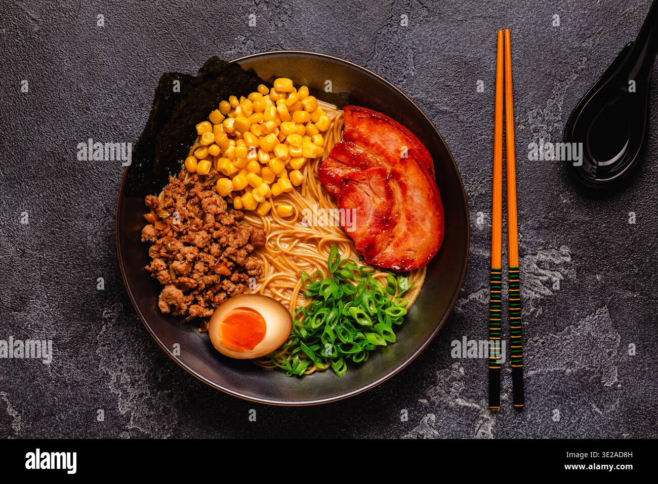 Una ciotola di ramen con spaghetti, carne e cipolle verdi, vista dall'alto. Foto Stock