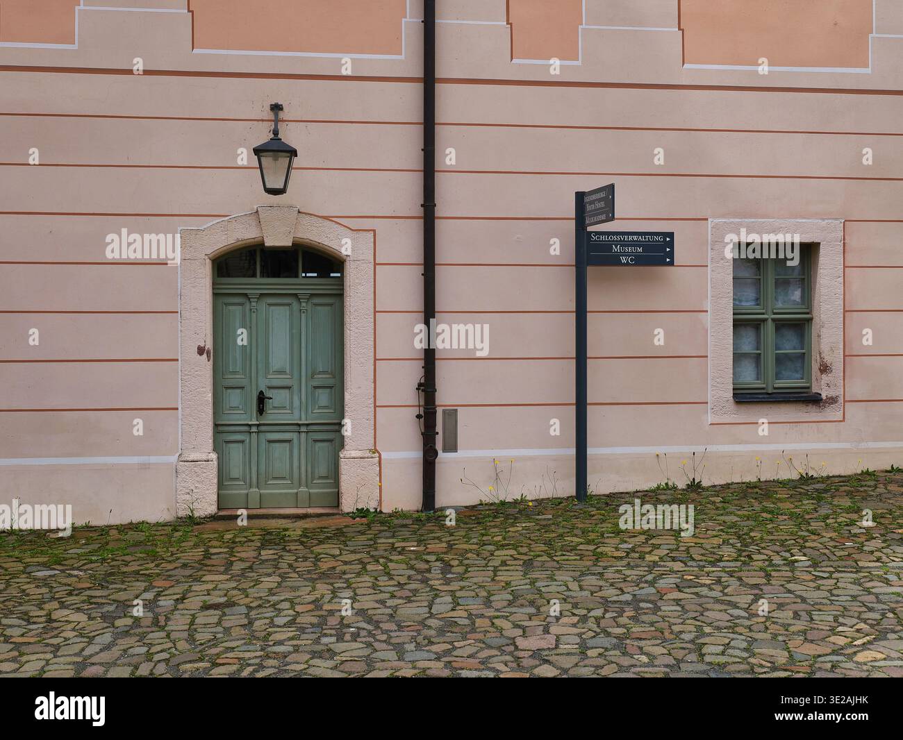 Castello di Colditz: Facciata storica con cancello verde e cartello per il museo e l'amministrazione del castello, ex campo di prigionia della seconda guerra mondiale Foto Stock
