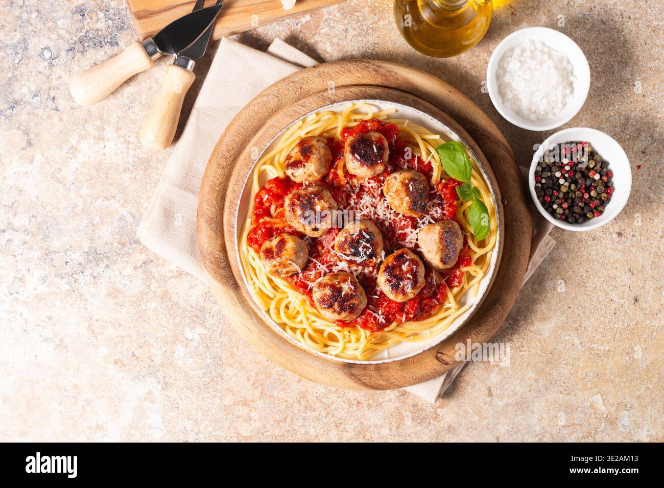 Un piatto di spaghetti classici conditi con polpette dorate e ricca salsa di pomodoro su un piatto di ceramica leggera. Foto Stock