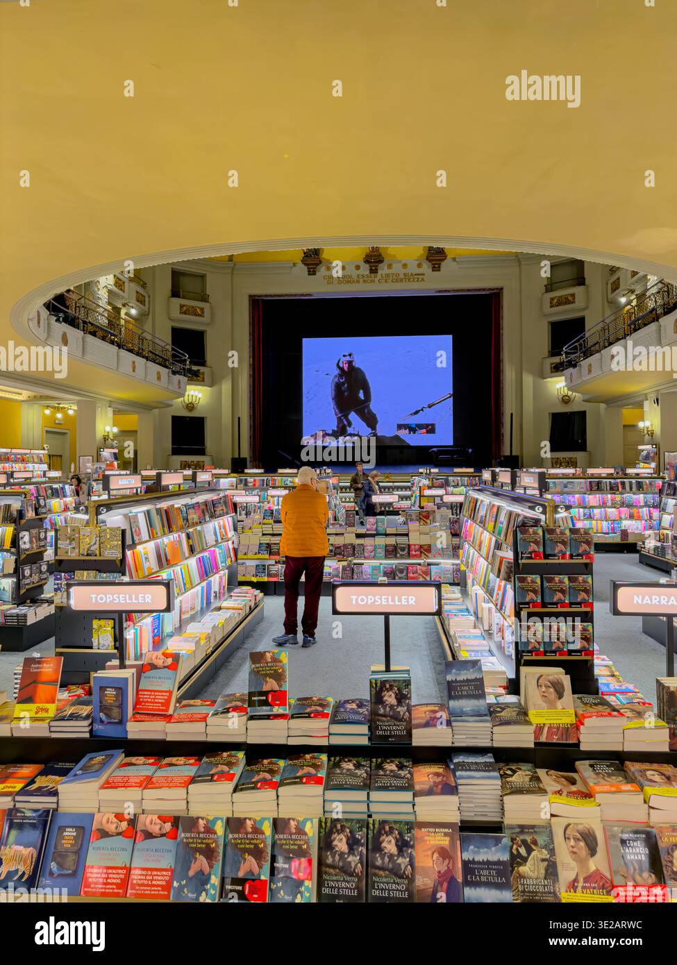 Persone che sfogliano libri al piano inferiore della sezione librerie di giunti Odeon Libreria e Cinema, una libreria combinata con cinema a Firenze, Italia Foto Stock