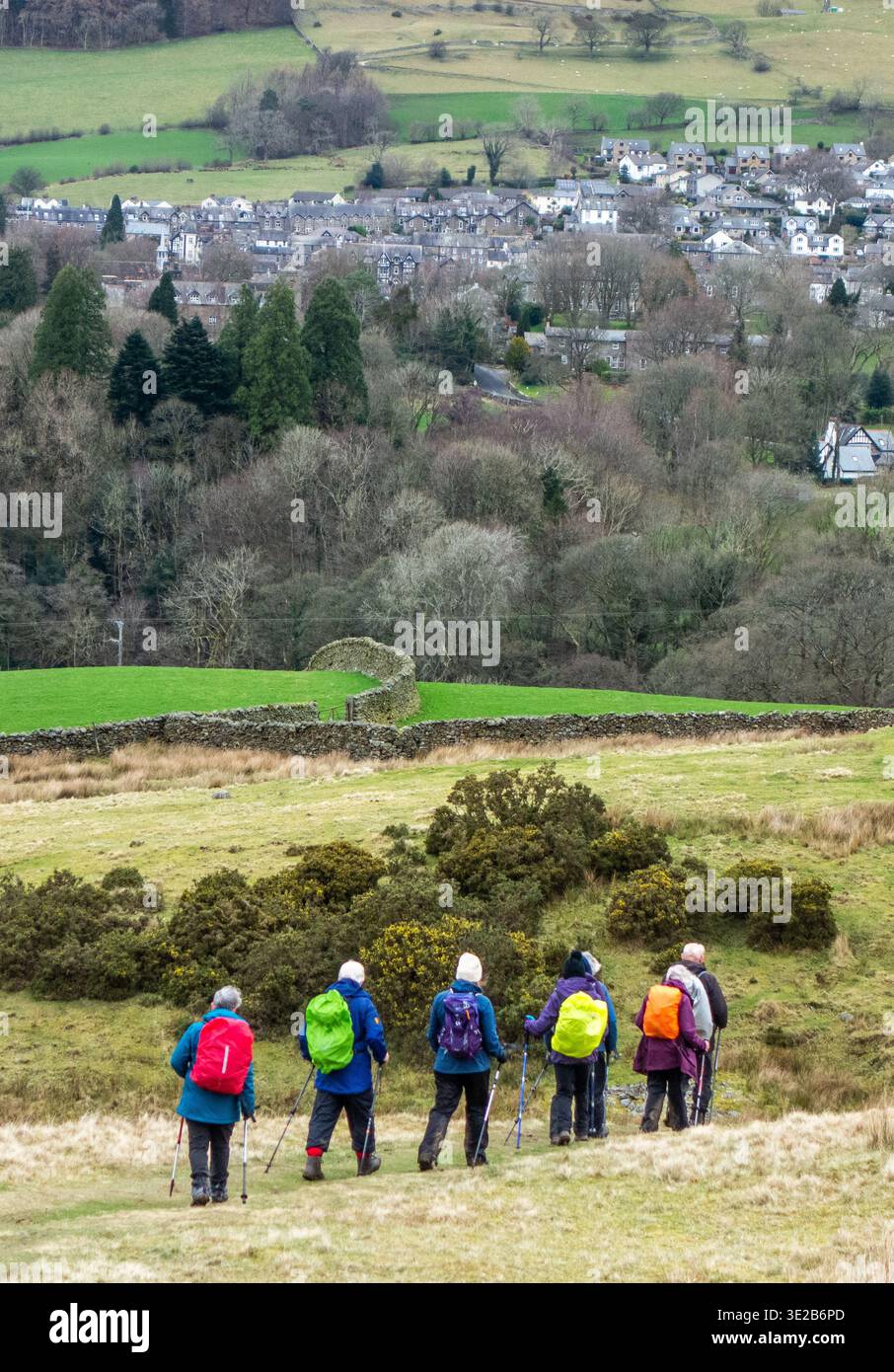 Gruppo di escursionisti che si arrampicano e fanno lo zaino in spalla lungo il sentiero di lunga distanza Dales Way che si avvicina al villaggio Cumbro di Sedbergh Foto Stock