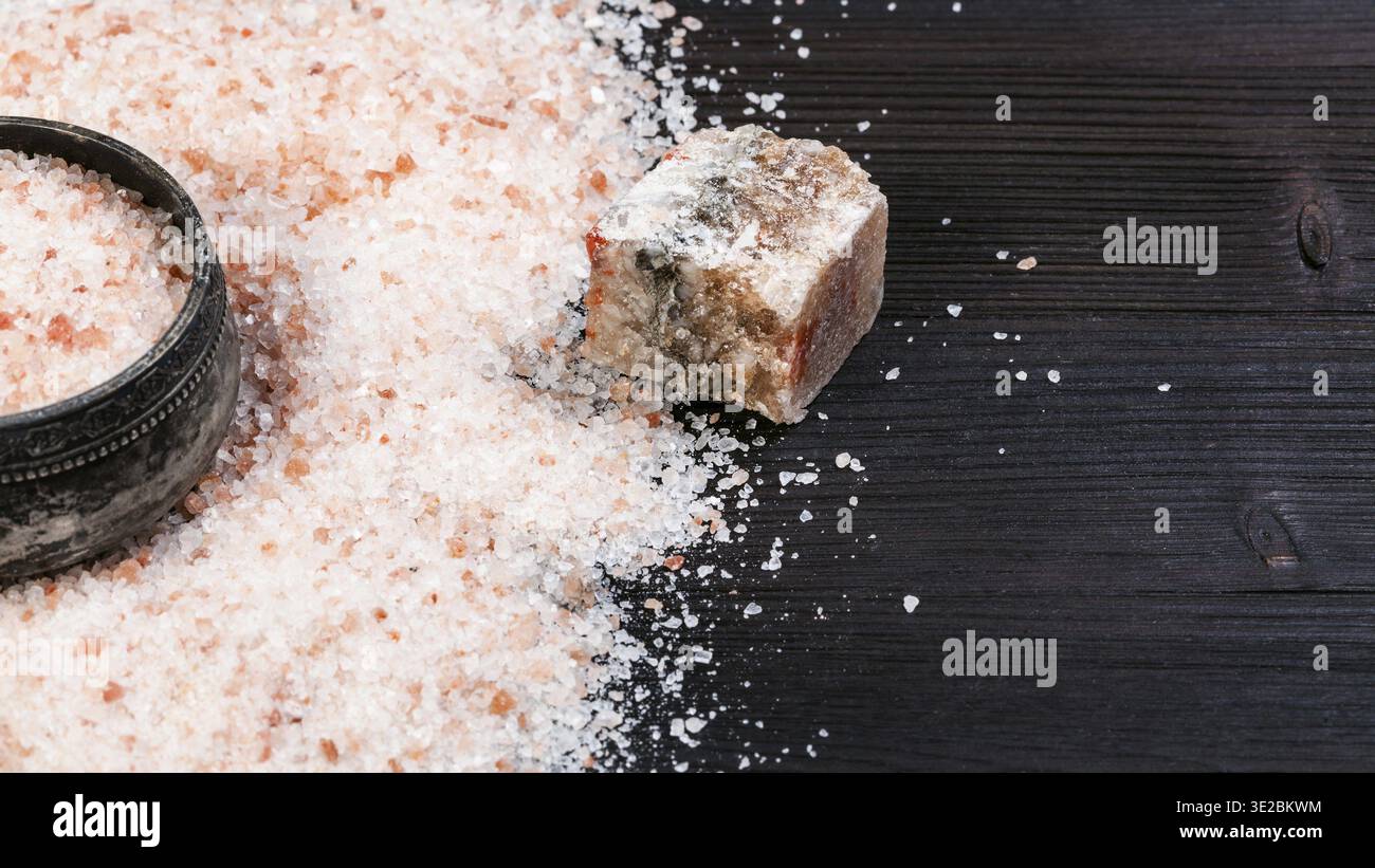 Cantina di sale d'argento vintage, minerale Halite rosa naturale grezzo e sale himalayano granulare su tavola di legno marrone scuro Foto Stock