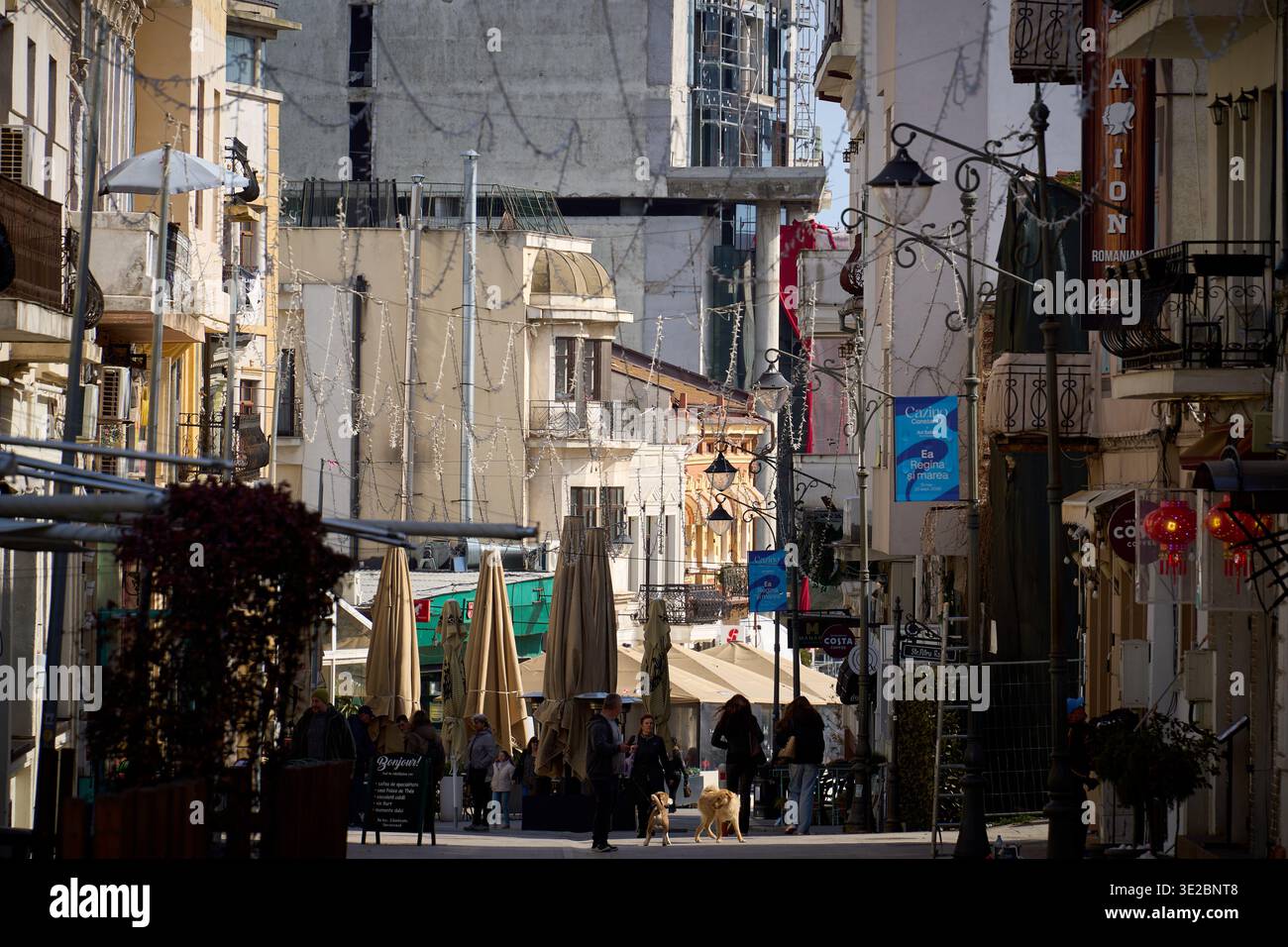 Costanza, Romania. 18 marzo 2026: Tomis Boulevard, una strada pedonale con edifici storici e luci a soffitto, è una popolare destinazione turistica Foto Stock