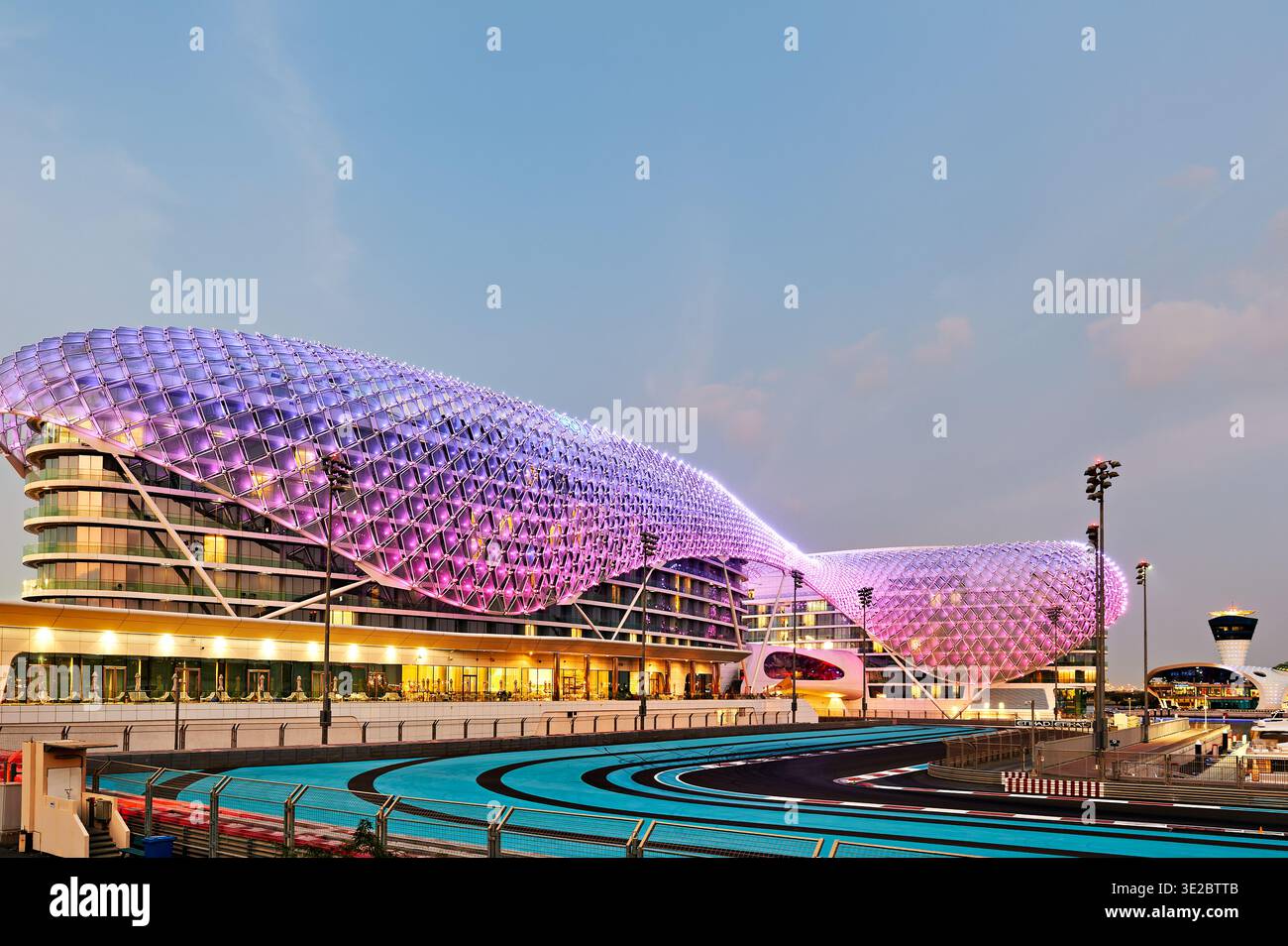 L'hotel W Abu Dhabi brilla di notte sull'isola Yas. L'iconica struttura è vicina al circuito. Molte luci creano una scena vibrante nella zona. Foto Stock