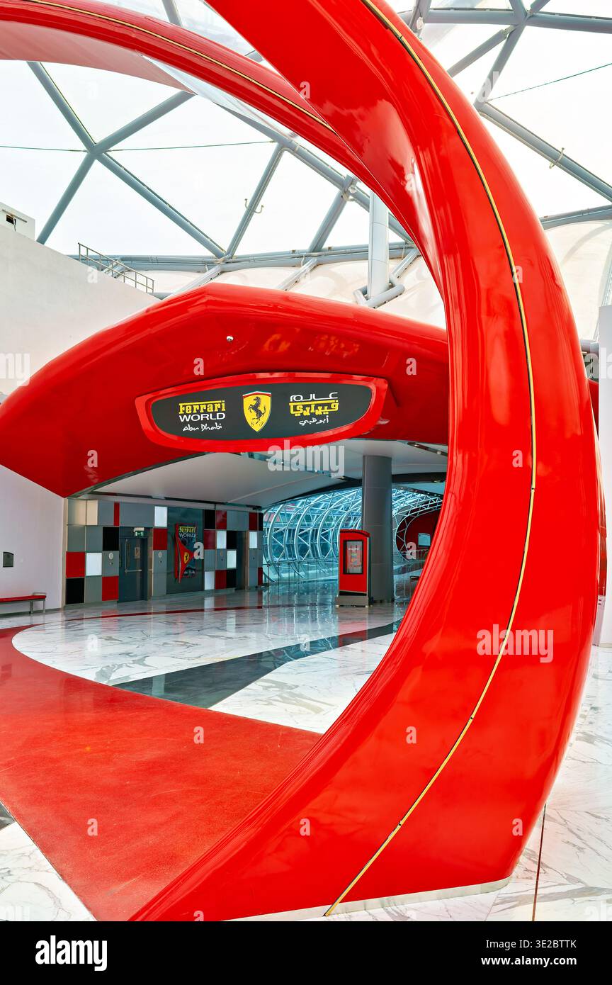 Le persone camminano attraverso l'area d'ingresso del parco a tema Ferrari World ad Abu Dhabi, godendosi le attrazioni e l'atmosfera al suo interno. Foto Stock