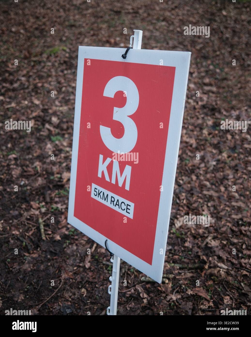 Un cartello segnaletico rosso per Una corsa di cinque chilometri in Un'area boscosa durante Un evento Park Run Foto Stock