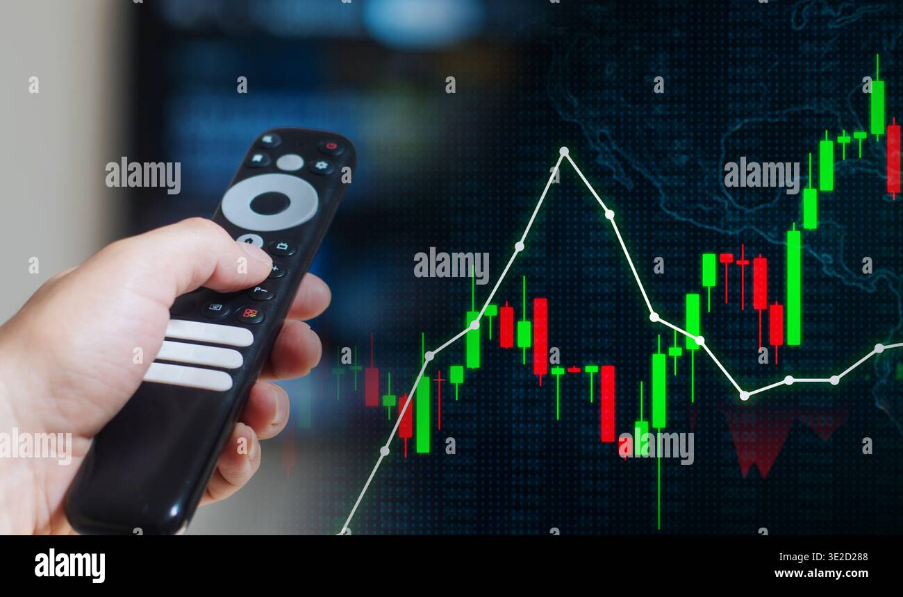 Puntare a mano il telecomando della televisione sul grafico del mercato azionario finanziario, monitorando il concetto di notizie sugli investimenti Foto Stock