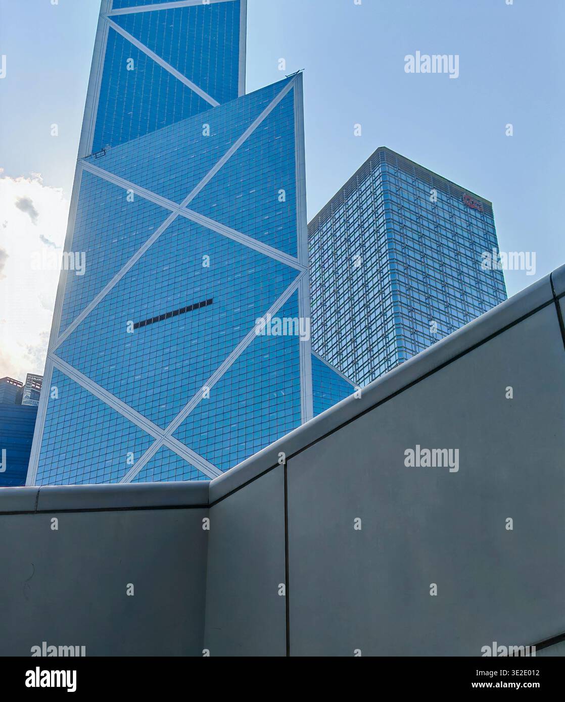 18 marzo 2026 - Hong Kong: Una suggestiva scena architettonica moderna caratterizzata da un grattacielo unico con una geometria angolare distintiva e vetro colorato blu Foto Stock