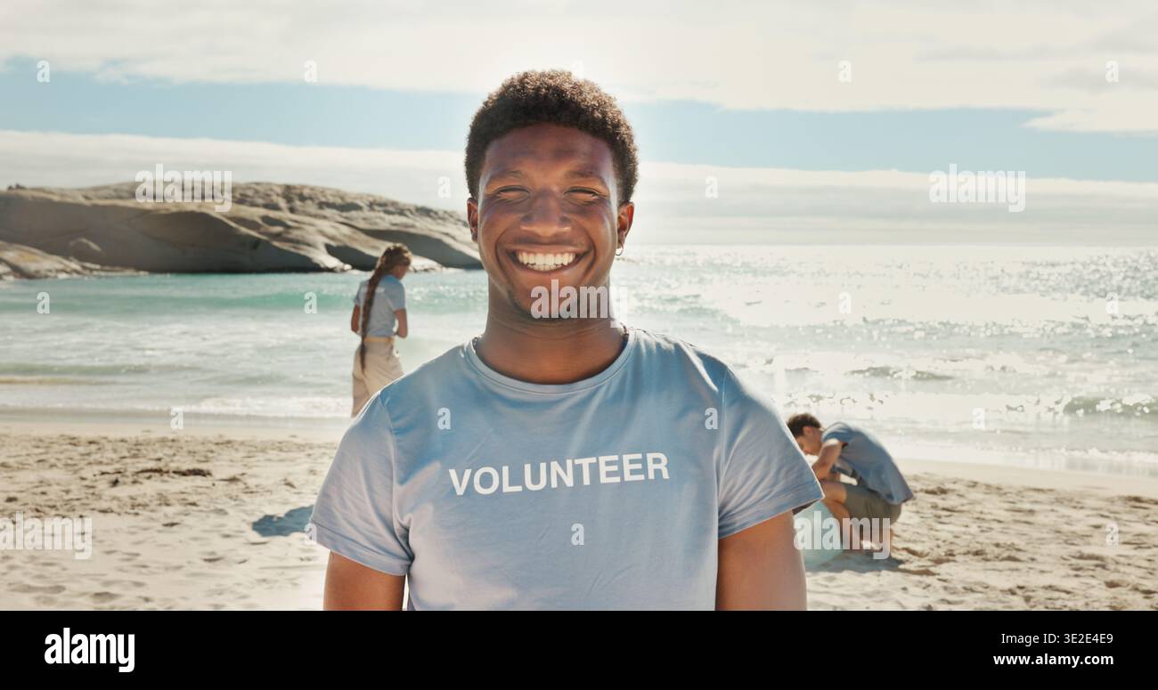 Sorridi, uomo e ritratto di volontario in spiaggia con fiducia per la responsabilità sociale. Happy, ONG e lavoratore di beneficenza maschile per la comunità Foto Stock