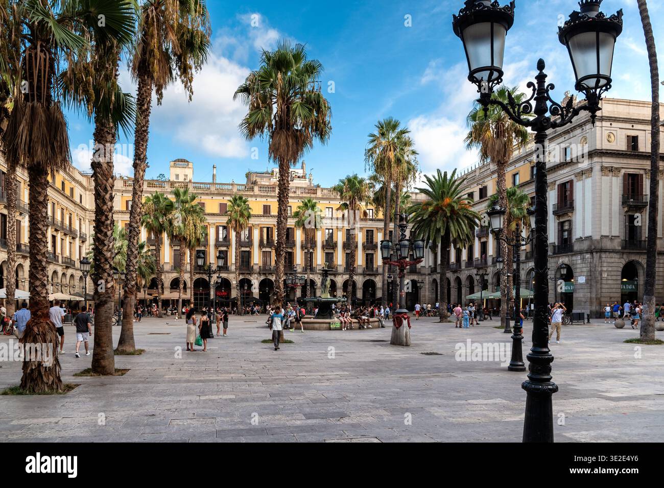 Barcellona, Spagna, 29 agosto 2024: La gente del posto e i turisti si rilassano in un accogliente cortile nella parte vecchia della città, che ospita numerosi caffè e riposo Foto Stock