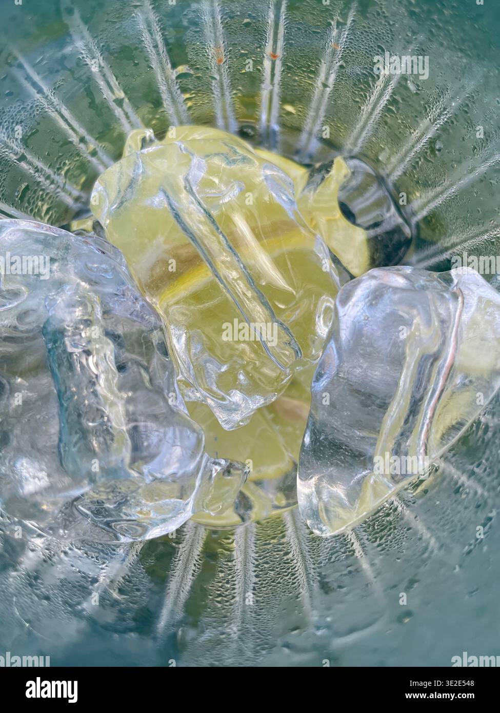 Rinfrescante pezzo di limone con cristalli di ghiaccio e umidità scintillante su sfondo vivace Foto Stock