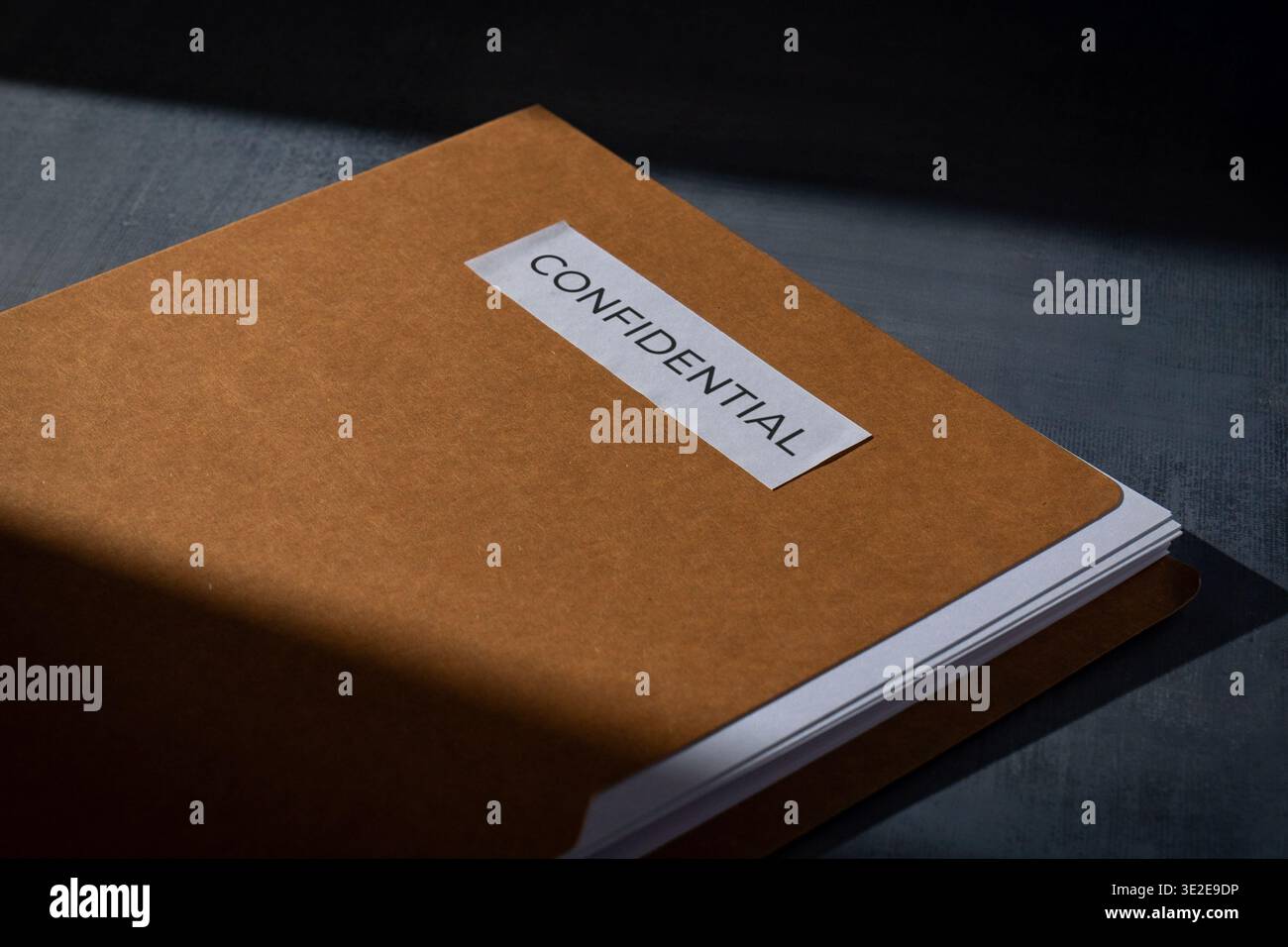 Cartella marrone manila con un'etichetta RISERVATA su una superficie scura. Segretezza aziendale, riservatezza dei dati, sicurezza legale e gestione delle informazioni sensibili Foto Stock