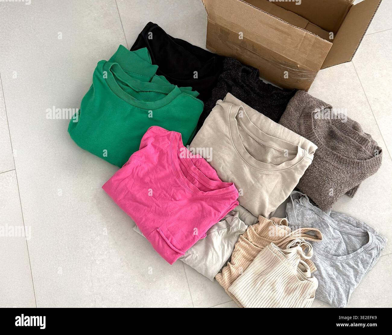 T-shirt piegate assortite in vari colori, tra cui verde, rosa, grigio e beige Foto Stock