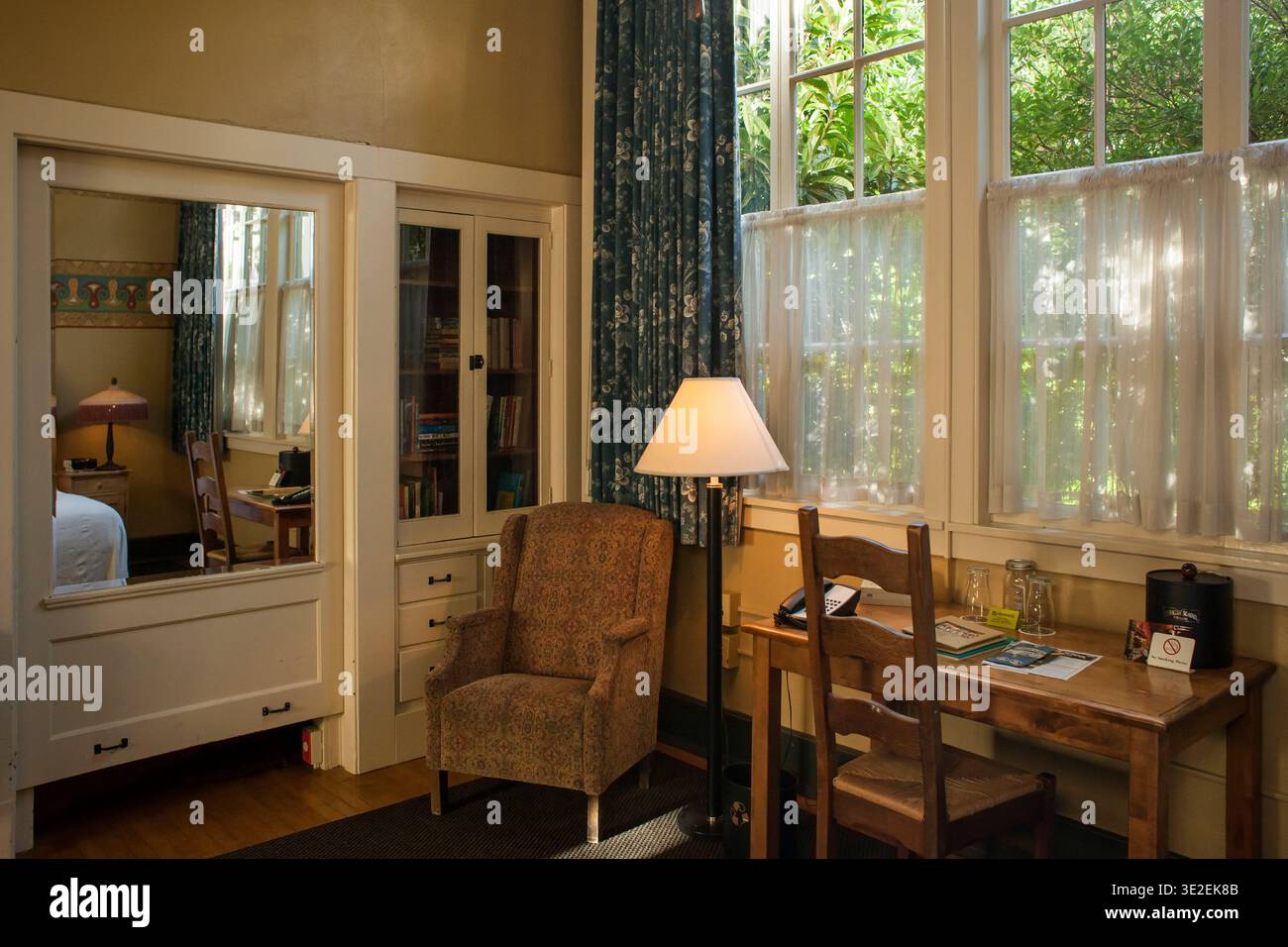 Interno di un'accogliente camera della Kennedy Elementary School con scrivania in legno, grandi finestre e poltrona a Portland, Oregon Foto Stock