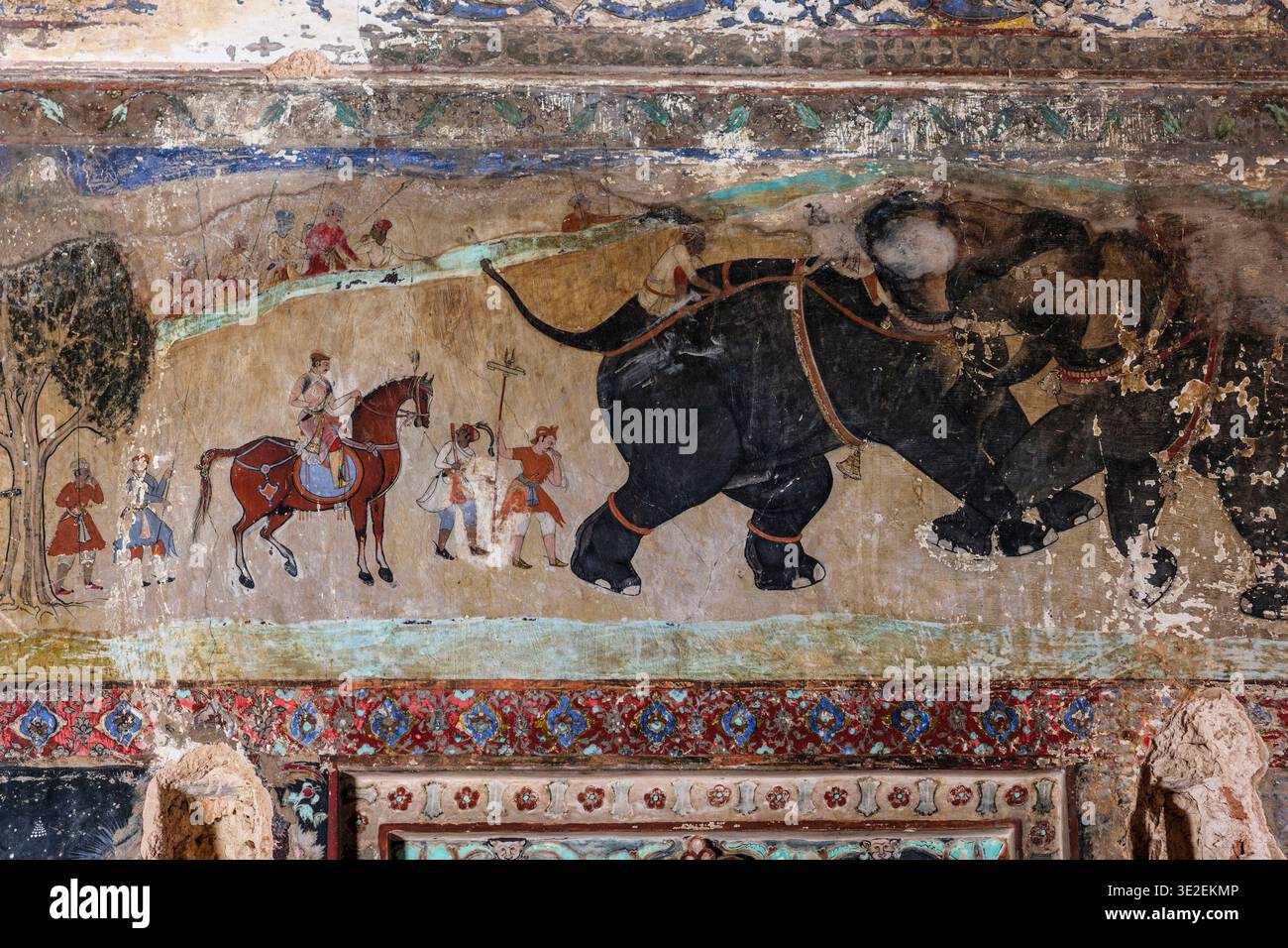Un murale nel Chitrashala di Bundi mostra due grandi elefanti che combattono mentre un nobile a cavallo e diversi assistenti guardano. Foto Stock