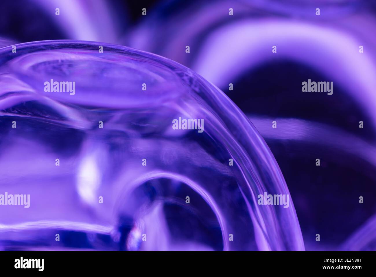 Composizione astratta di una scatola di plastica capovolta che riflette la luce viola dal basso. Foto Stock